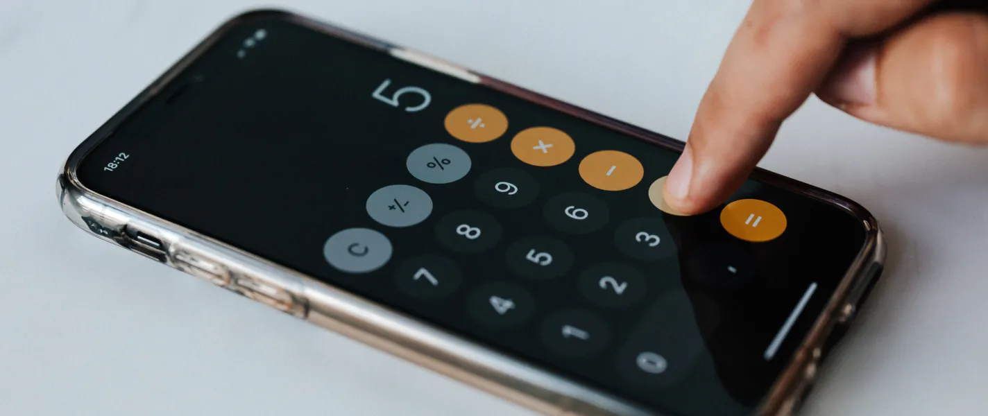 En person er i gang med at bruge lommeregneren på en telefon