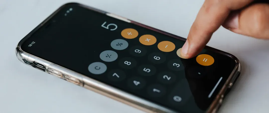 En person er i gang med at bruge lommeregneren på en telefon