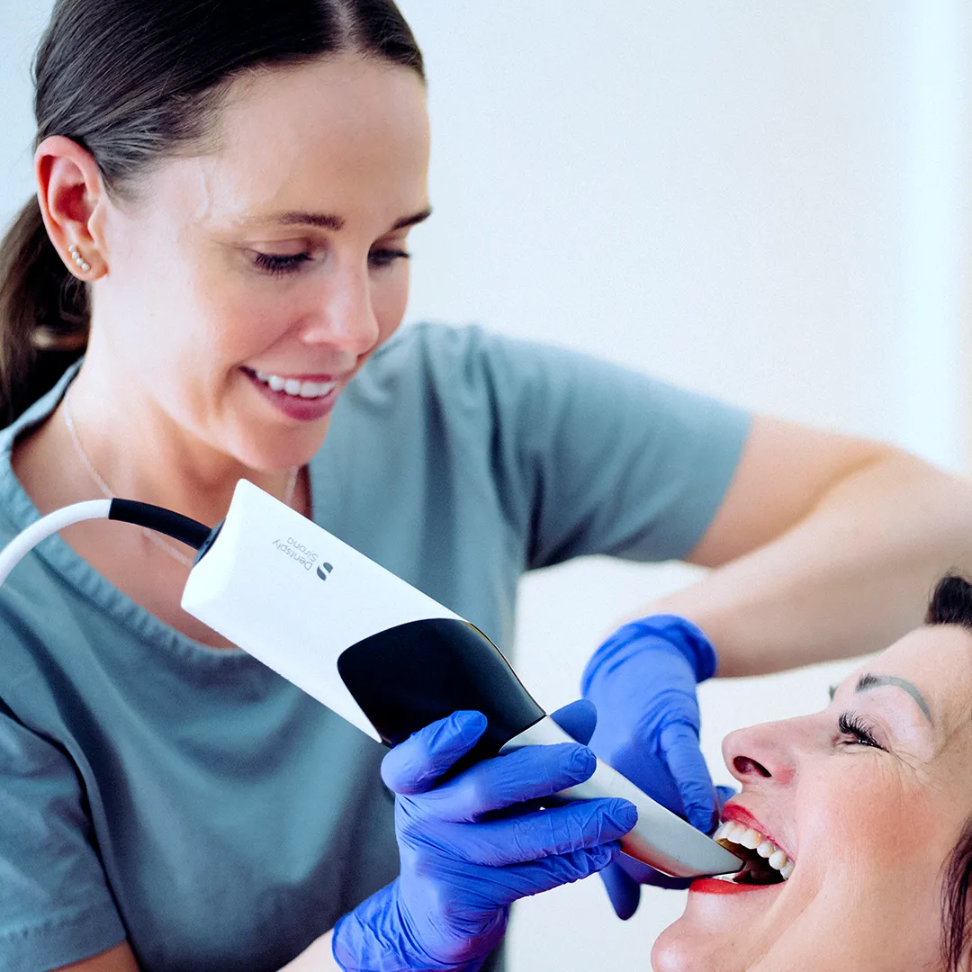 Klinikassistent scanner patient som smiler med intraoralscanner