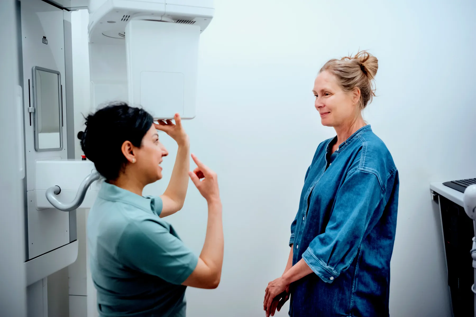 Klinikassistent gør en patient klar til 3D-scanning af kæben
